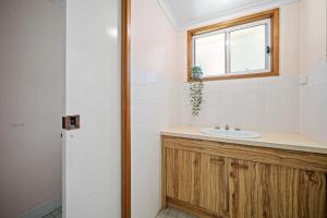 a bathroom with a sink and a window at Burrill Lake Cottage in Burrill Lake +20 photos