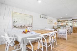 a kitchen and dining room with a table and chairs at Coast House Mollymook in Mollymook +15 photos