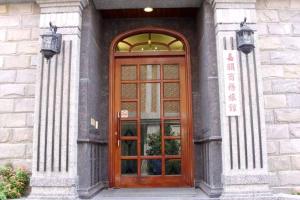 a wooden door on a building with two lights at Jia Yun Business Hotel in Yongkang