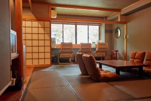 Habitación con mesa, sillas, mesa y sillas. en Towadakohan Sakura en Towada