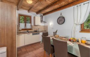 a kitchen and dining room with a table and a clock at Lovely Home In Dolinci With Outdoor Swimming Pool in Grižane