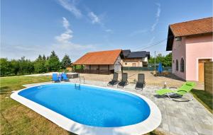 - une piscine dans une cour avec des chaises et une maison dans l'établissement Amazing Home In Turnisce With Outdoor Swimming Pool, 