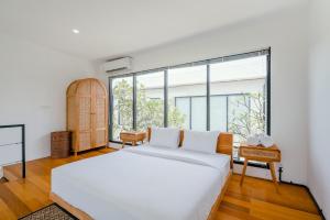 a bedroom with a white bed and a large window at Canggu 2Plex Apartment in Canggu +48 photos