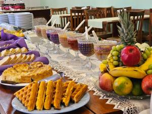 uma mesa coberta com pratos de comida e taças de vinho em Pousada Monte Silvestre em Monte Verde