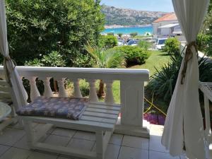 un banco sentado en un porche con vistas al océano en APARTMAN 1 en Baška