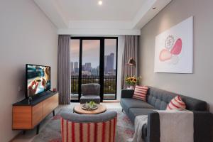 a living room with a couch and a tv at Citadines Gatot Subroto Jakarta in Jakarta