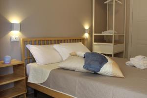 een slaapkamer met een bed met witte lakens en kussens bij Aurora BnB in Pisa