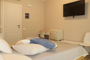 a bedroom with a bed with a television on the wall at Aurora BnB in Pisa
