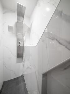 a bathroom with white walls and a glass wall at Appartement tout équipé au coeur du Panier Vieux Port in Marseille