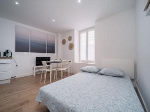 a white bedroom with a bed and a table at Appartement tout équipé au coeur du Panier Vieux Port in Marseille