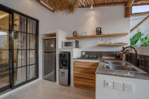 a kitchen with a sink and a refrigerator at Villa Ruta II - Luxury 2BR tropical villa next to Luna BC and Nyanyi beach in Tanah Lot