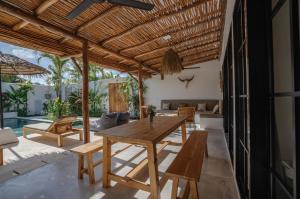 an outdoor dining room with a wooden table and benches at Villa Ruta II - Luxury 2BR tropical villa next to Luna BC and Nyanyi beach in Tanah Lot +31 photos