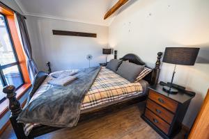 ein Schlafzimmer mit einem Bett und einer Lampe auf einer Kommode in der Unterkunft Wallabies, parrots, farm animals in St Helens
