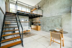 a spiral staircase in a room with a table and chairs at Canggu 2Plex Apartment in Canggu