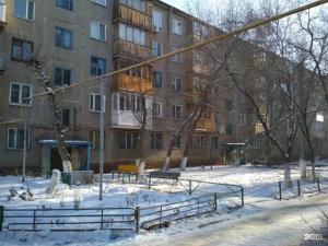 un parque cubierto de nieve frente a un edificio en Новый Люкс в центре города по Алиханова, en Karagandá