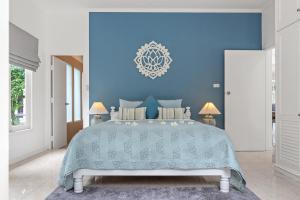 a blue bedroom with a large bed with a blue wall at 2BR Villa Baan Chanchai, seconds to beach in Lamai +64 photos