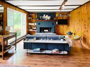 a living room with a blue couch and a fireplace at Haven Retreat in Catskills w Hot Tub & Bar Hall in Sundown