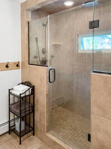 La salle de bains est pourvue d'une douche avec une porte en verre. dans l'établissement Haven Retreat in Catskills w Hot Tub & Bar Hall, à Sundown