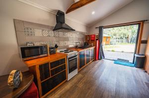 a kitchen with a stove and a microwave at Wallabies, parrots, farm animals in St Helens