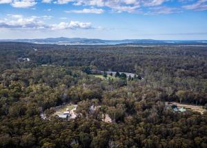 an aerial view of a house in the middle of a forest at Wallabies, parrots, farm animals in St Helens