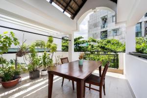 a dining room with a table and chairs and windows at The Lovenote Home in Ho Chi Minh City