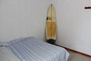 プエルト・チカマにあるTITI SURF CHICAMAのベッドルーム1室(ベッド1台、壁に傾いたサーフボード付)