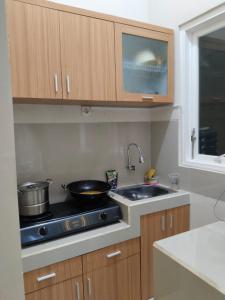 uma cozinha com um fogão e um lavatório em Villa keluarga sejahtera em Batu