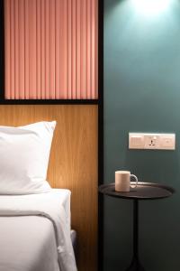 a room with a bed and a table with a coffee cup at The Bayou Hotel Langkawi in Pantai Cenang