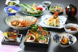 a table with plates of food and bowls of food at Kii no Matsushima in Kihokucho