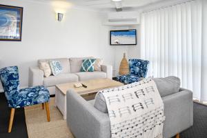 a living room with a couch and a table at Stylish 2 B/R Kings Beach Apartment (6 guests) ZF4 in Caloundra