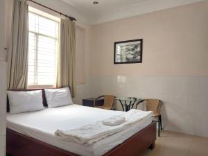 a bedroom with a bed and a table and a window at Khách sạn Mai Hoàng 2 in Ho Chi Minh City