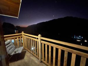 a balcony with a view of the mountains at night at Pousada Monte Silvestre in Monte Verde