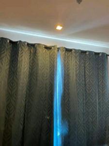 BASE Central PATTAYA Quiet Room with Infinity Pool & Free Netflix في باتايا سنترال: غرفة بها ستارة مع ضوء أزرق