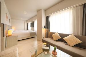 鹿儿岛QuintessaHotel KagoshimaTenmonkan Relax&Sleep的酒店客房,配有床和沙发