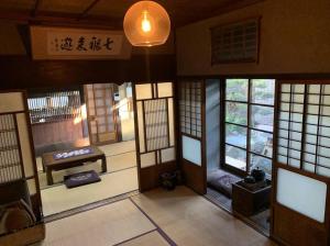 pokój z drzwiami i oknami w budynku w obiekcie Old Japanese House w mieście Tondabayashi