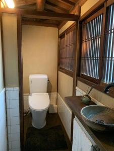 małą łazienkę z toaletą i umywalką w obiekcie Old Japanese House w mieście Tondabayashi