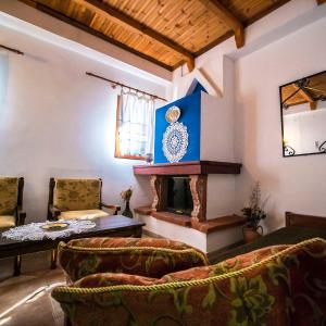 a living room with a fireplace and a table and chairs at Αρχοντικό Κονάκι- Konaki Pelion in Tsagarada