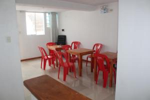 uma sala de jantar com mesas de madeira e cadeiras vermelhas em TITI SURF CHICAMA em Puerto Chicama
