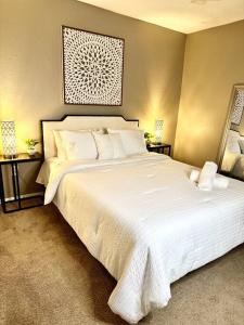 a bedroom with a large white bed with white sheets at Summer Getaway in Fondren! Sleeps 6 with pool Access! in Jackson