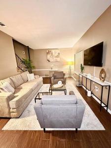 sala de estar con sofá y TV en Summer Getaway in Fondren! Sleeps 6 with pool Access! en Jackson