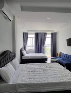 1 Schlafzimmer mit 2 Betten, einem Sofa und einem Fenster in der Unterkunft Motel Lim in Vũng Tàu