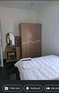 Schlafzimmer mit einem Bett, einer Kommode und einem Spiegel in der Unterkunft Motel Lim in Vũng Tàu