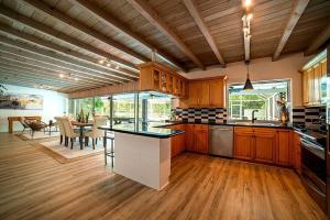 uma grande cozinha com armários de madeira e uma sala de jantar em Luxury Miami Village w/Pool+Grill+MiniGolf em Miami