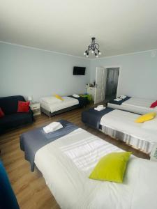 a room with three beds and a couch at Gladiator Noclegi Zator lV Apartament in Zator