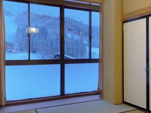 a room with a window with a view of a snowy mountain at Minamiuonuma - Hotel - Vacation STAY 36571v in Seki