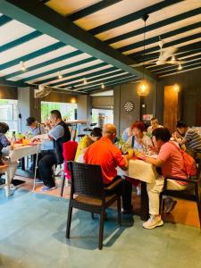 een groep mensen die aan tafel zitten in een restaurant bij Morning Star Resorts in Negombo