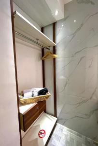 a bathroom with a walk in shower and a sink at oxy suites G-03 at Shop House Meisterstadt Pollux Habibie in Batam Center