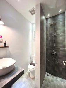 een badkamer met een wastafel, een toilet en een douche bij oxy suites G-03 at Shop House Meisterstadt Pollux Habibie in Batam Center