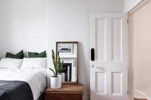 a bedroom with a bed and a mirror at Belstone cottage - 1880’s terrace at French Street in Launceston