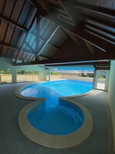 ein großer Pool mit blauem Wasser in einem Gebäude in der Unterkunft Le Paradis d'ARAN in Luchon